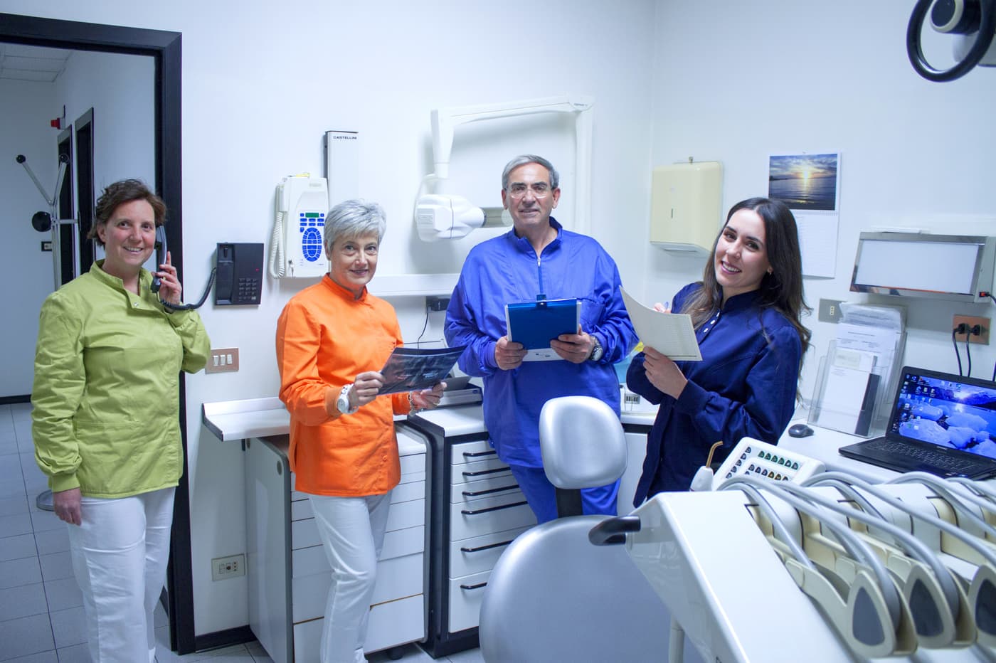 Il team dello studio nella sala di cura, con la dottoressa che consulta una cartella